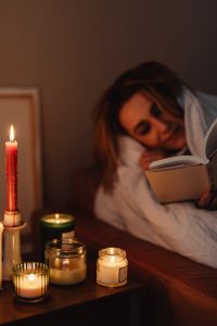 Kaboompics - Candlelight Reading Under a Blanket at Home