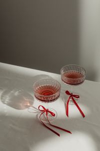 Kaboompics - Crystal Glasses with Red Drinks and Satin Ribbon Bows