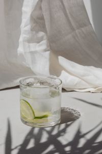 Kaboompics - Lime Water Glass beside Draped White Fabric, Bright Window Shadows and Copy Space