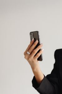 Kaboompics - Smartphone Held in Hand by a Woman in a Black Suit