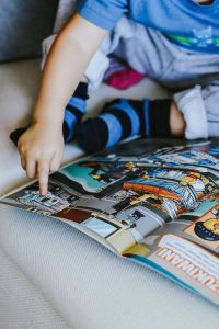 Kaboompics - Child reading a comic story