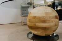 Kaboompics - Sculptural Wooden Sphere on Glass Table in Contemporary Showroom
