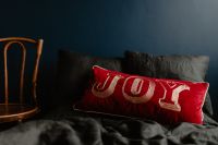 Kaboompics - Red Joy Pillow in a Cozy Holiday Bedroom