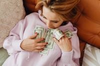 Kaboompics - Overhead View of Woman Holding Dollar Bills Against Her Chest