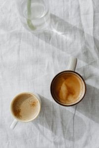 Kaboompics - Two Coffee Cups on White Linen with a Glass Vase