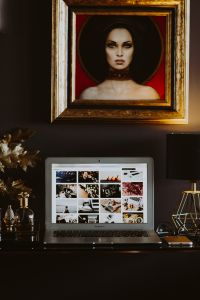 Kaboompics - Home Office Wall with Framed Portrait, Laptop and Gold Lamp