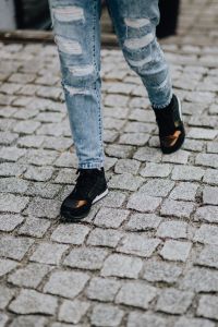 Woman in black sneakers and blue jeans