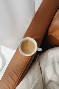 Kaboompics - Overhead Coffee on Cognac Leather and Neutral Knit Throw for Cozy Home Moodboards