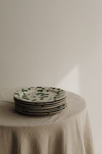 Kaboompics - Green Splatter Plate Stack with Soft Natural Light and Copy Space