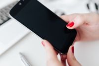 Kaboompics - Businesswoman uses her mobile phone at her desk