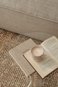 Kaboompics - Neutral Sofa Styling with Candle, Open Book and Textured Rug
