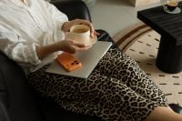 Kaboompics - Coffee Break With Laptop and Orange Phone on Woman’s Lap
