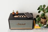 Kaboompics - Black speaker on marble table, white wall, mobile phone