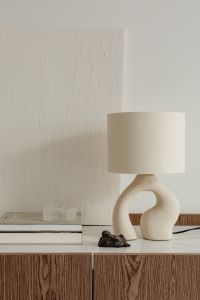 Kaboompics - Sculptural Cream Table Lamp with a Dark Ceramic Accent on a Minimal Sideboard