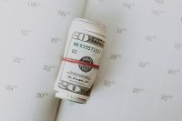 Kaboompics - Rolled US Twenty-Dollar Notes Tied with Red String on a Calendar Page