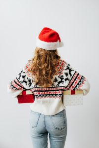 Kaboompics - Rear View of Woman Carrying Gift Boxes in a Santa Hat