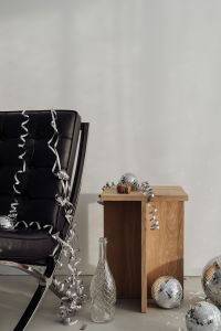 Kaboompics - Black Chair and Wooden Side Table Styled with Disco Ball and Champagne Bottle