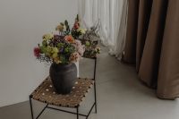 Kaboompics - Wide Interior View of Dark Vase Bouquet on Woven Accent Stool