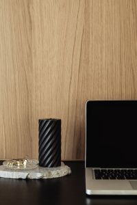 Kaboompics - Black Spiral Candle Beside Laptop on Warm Wood Desk, Minimal Home Office