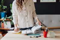 Kaboompics - Woman Standing Beside Open Books at Desk