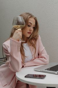 Kaboompics - Woman Holding a Wine Glass Beside a Laptop