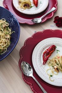Kaboompics - Overhead Seafood Dinner Table with Blue Pasta Bowl and Red Plates