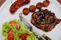 Kaboompics - Grilled Pork Neck Steak with Sausage and Fresh Salad on a White Plate