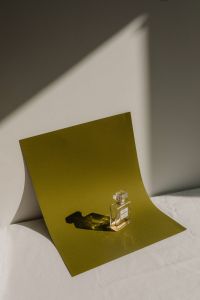 Kaboompics - Perfume Bottle on an Olive Green Paper Backdrop