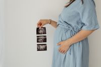 Kaboompics - Pregnant Woman in Beige Dress Touching Her Lower Back