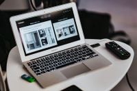 Kaboompics - White laptop on a table with a remote