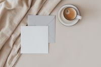 Kaboompics - Overlapping Blank Card and Envelope beside Cappuccino on Cream Linen