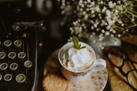Kaboompics - Whipped Cream Coffee with Mint and Cookie beside Typewriter, Eyeglasses and White Flowers