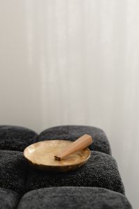 Kaboompics - Close-Up of Palo Santo in a Mother-of-Pearl Bowl on a Black Textured Ottoman