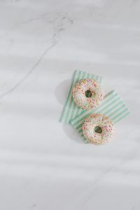 Kaboompics - Donuts on paper napkins placed on white marble