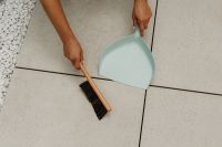 Kaboompics - Woman Sweeping White Decorative Stones Along a Floor Edge