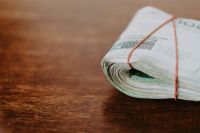 Kaboompics - Close-Up of Rolled Polish Zloty Banknotes Bound with Red String on Wood