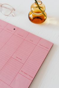 Kaboompics - Pink Weekly Planner with Glasses and Amber Vase for Work and Goal-Setting Content