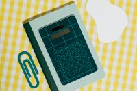 Kaboompics - Close-Up of a Green Calculator and Paper Clip on Yellow Gingham
