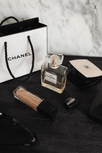 Kaboompics - Chanel Perfume, Makeup and Compact on Black Textured Surface