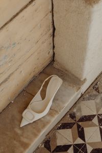 Kaboompics - White high-heeled open-back pumps with front embellishment - Pointed toe - Ankle strap