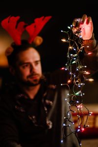 Kaboompics - Man Wearing Reindeer Antlers Holding Twinkling Holiday Lights