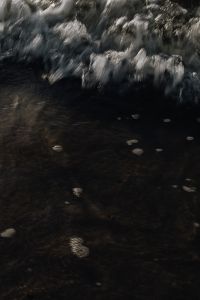 Kaboompics - Foamy Surf Above Dark Wet Sand, Vertical Coastal Texture