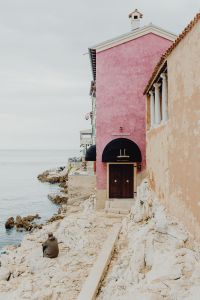 Kaboompics - Pastel Pink Seaside Building on Rocky Shoreline in Rovinj