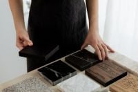 Kaboompics - Hands Arranging Black Marble and Wood Swatches with Stone Color Palette