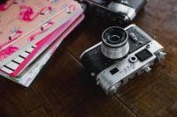 Kaboompics - Old analog cameras and pink books on a wooden table