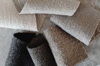 Kaboompics - Rolled Neutral Bouclé Upholstery Fabric Samples and Fabric Swatches on Stone