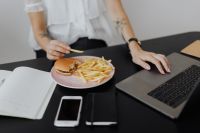 Kaboompics - Woman Holding Burger While Working on Laptop
