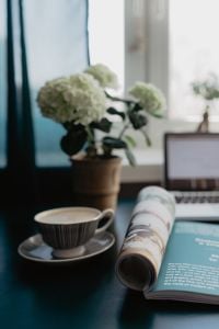 Magazine Reading with Coffee and Laptop Workspace