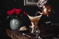Kaboompics - Copper Kettle Pouring into a Chemex beside Red Roses and a Gold Coffee Cup on Rustic Wood
