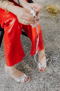 Kaboompics - Woman in red pants and a white shirt is sitting on a chair with confetti